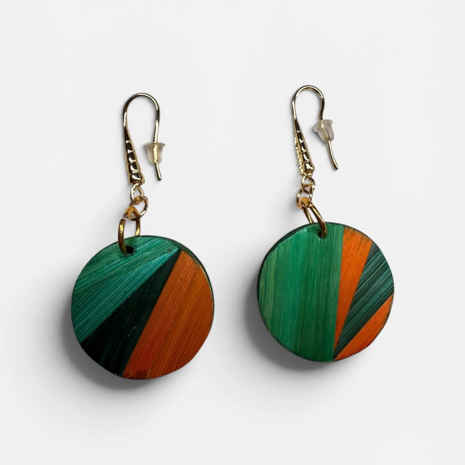 Boucles d'oreilles médaillon — formes rondes en paille teintée orange et verte, crochets acier inoxydable, fond blanc