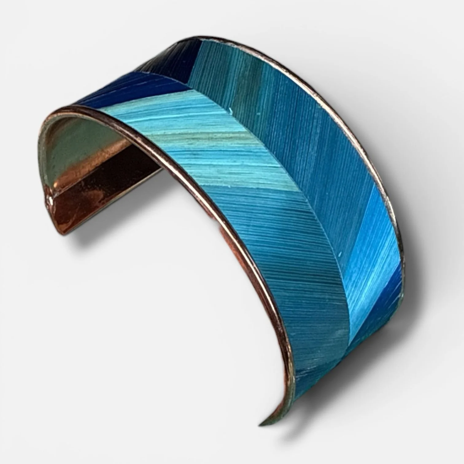 Bracelet manchette grand bleu vu sous un autre angle — marqueterie de paille de seigle teintée bleu sur manchette laiton cuivré, fond blanc